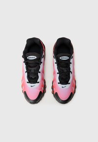 Tenisky Nike Air Max majú hornú časť v gradientnej kombinácii ružovej a bielej farby s čiernymi akcentmi a šnúrkami. Podrážka má viditeľné vzduchové vankúšiky a textúrovaný vzor.