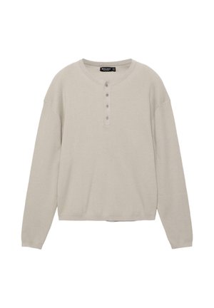 Maglione beige a maniche lunghe in maglia coste con scollatura rotonda e pattina con quattro bottoni, vestibilità rilassata.