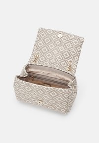 Sac tissé beige texturé avec un motif géométrique, quincaillerie dorée, fermeture magnétique et un intérieur clair comprenant un emplacement pour carte et une poche zippée.