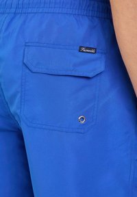 Blauwe zwembroek van lichtgewicht stof met een elastische tailleband, een achterzak met klep en een metalen oogje detail.