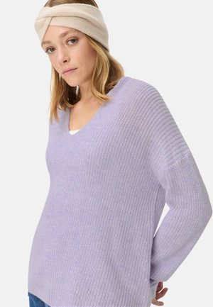 Helllila, V-Ausschnitt Strickpullover mit strukturiertem Rippdesign. Mit langen Ärmeln und lockerer Passform. Trägt ein cremefarbenes Haarband.