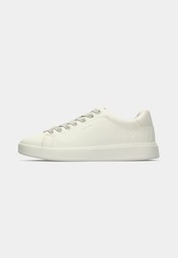 Sneaker bassa in pelle bianca con chiusura a lacci e suola in gomma piatta mostrata di lato su uno sfondo neutro.