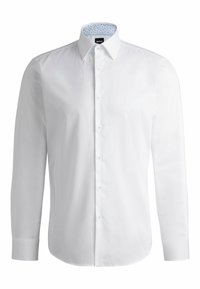 Witte langzamige shirt met een kraag, voorzien van een blauw patroon aan de binnenkant van de kraag en knoopsluitingen aan de voorkant. Gladde textuur.