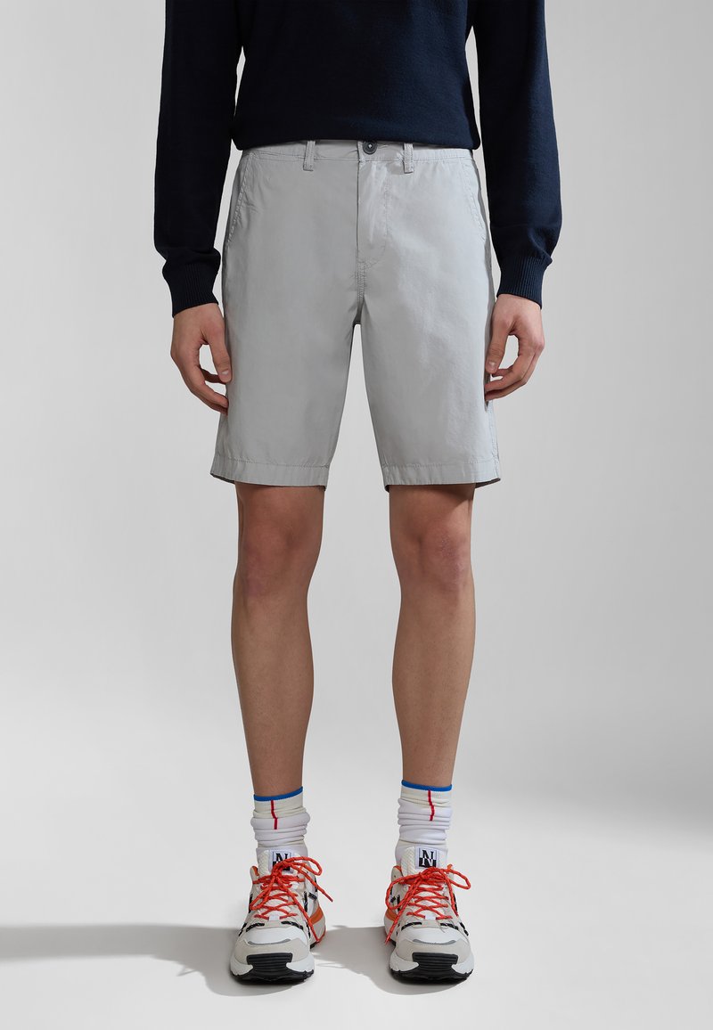 Lys grå shorts med sidelommer, lavet af åndbart stof. Har en standard talje og lige snit, parret med sneakers.
