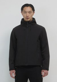 Giacca nera con cappuccio realizzata in tessuto morbido e leggero. Presenta una zip frontale, tasche laterali e cordini regolabili sul cappuccio.