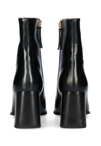 Stivaletti alla caviglia in pelle nera con finitura lucida, tacco alto quadrato e cerniere laterali. Presentano una texture liscia e un design minimalista.