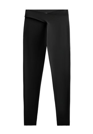 Fekete leggings sima, rugalmas anyagból. Magas derékkal és testhezálló sziluettel rendelkezik, egyenes vágással a bokákra.