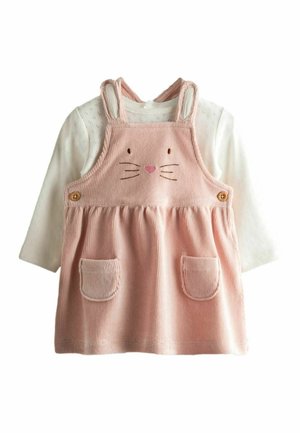 Bela otroška majica z dolgimi rokavi pod roza kordurovo obleko z motivom zajčjega obraza, ušesi, brki in sprednjimi žepi.