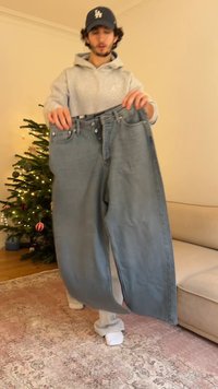 Hele sinised teksapüksid, mida kannab inimene, esitlevad nupufly ja viit taskut ning on lõdva istuvusega. Pehme tekstuuriga, kulunud välimusega ja minimaalsete kahjustustega.