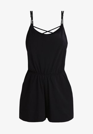 Combinaison noire avec des bretelles spaghetti fines, des détails entrecroisés au niveau du col, et une taille élastiquée. Tissu lisse et longueur courte.