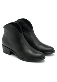 Par de botas de cuero negras hasta el tobillo con tacones bajos y cremalleras laterales sobre un fondo blanco.
