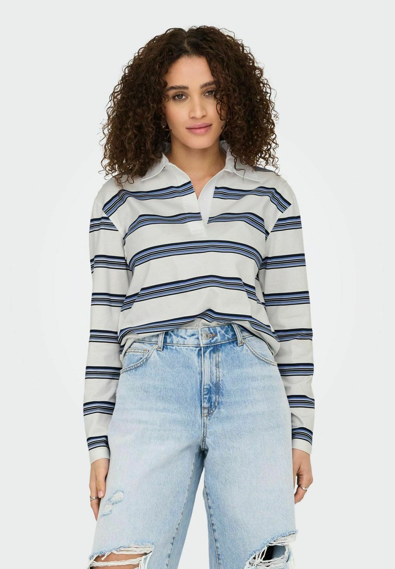 Long-sleeve, collared shirt in light gray with blue horizontal stripes. Worn with high-waisted, distressed light blue denim jeans.
