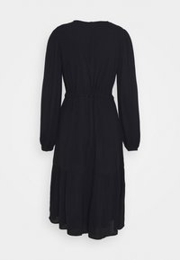 Schwarzes Kleid mit tailliertem Schnitt, langen Ärmeln und gestuftem Rock. Aus leichtem Stoff gefertigt, mit rundem Ausschnitt und elastischem Bund.