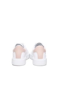 Sneaker bianchi con un morbido accento in pelle rosa sul tallone. Parte superiore in materiale sintetico liscio e suola in gomma bianca. Chiusura con lacci e colletto imbottito.