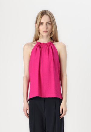 Rosa halterneck topp med samlet halslinje og løs silhuett. Lett stoff med en glatt tekstur. Sammen med mørke bukser.