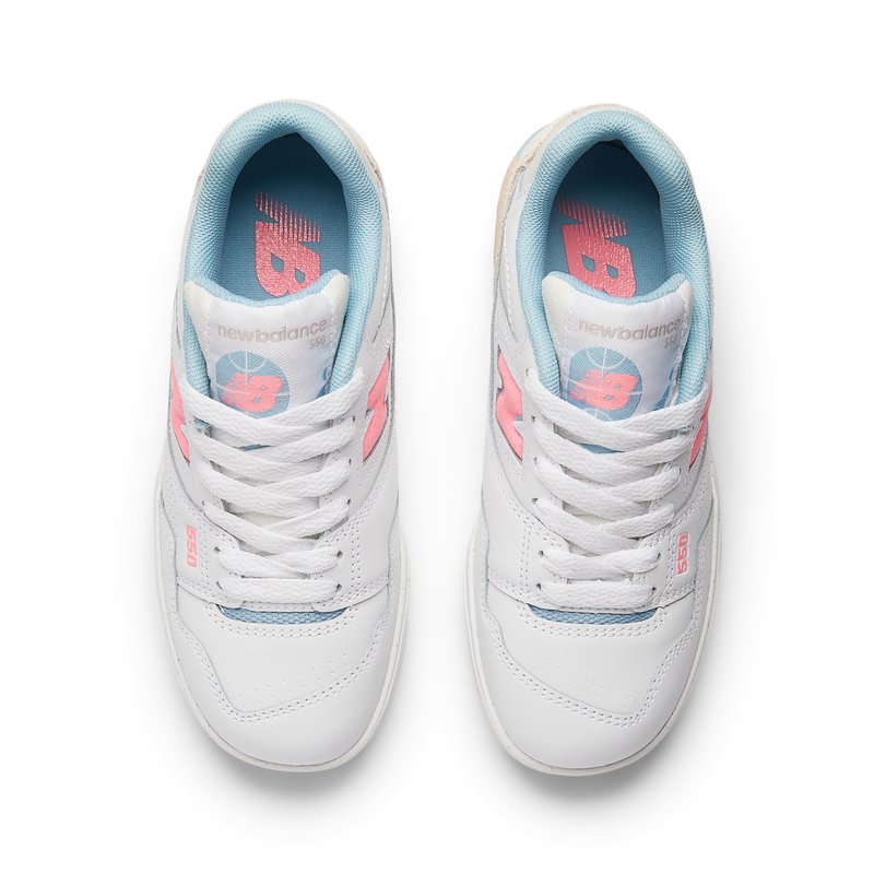 Sneakers bianche in pelle con una texture liscia, caratterizzate da dettagli azzurri e rosa, una linguetta imbottita e un logo "New Balance" su ogni lato.