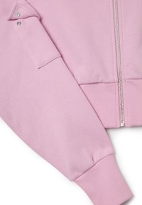 Felpa con zip rosa chiaro, caratterizzata da polsini e orlo a costine, texture morbida e dettaglio a bottoni a scatto sulla manica.