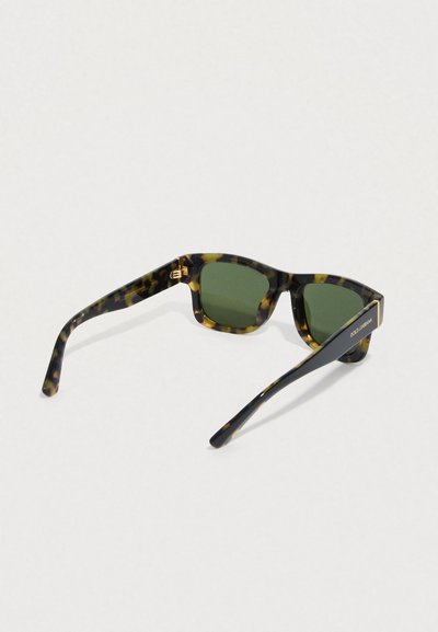 Sončna očala s tortoiseshell vzorcem in zelenimi lečami. Kvadratna oblika okvirja z zlatimi poudarki in črnimi stranicami z blagovno znamko.