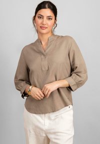 Beige, lehká blůza s mandarínkovým límcem, třičtvrtinovými rukávy a zaobleným lemem. Disponuje jemným prošíváním a malými knoflíkovými doplňky.