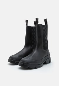 BOTTINES NOIRS CHEVILLE AVEC UN EXTÉRIEUR EN CUIR LISSE, PANNEAUX ÉLASTIQUES LATÉRAUX AVEC UN DESIGN MOTIF, ET UNE SEMELLE EN CAOUTCHOUC ÉPAIS.