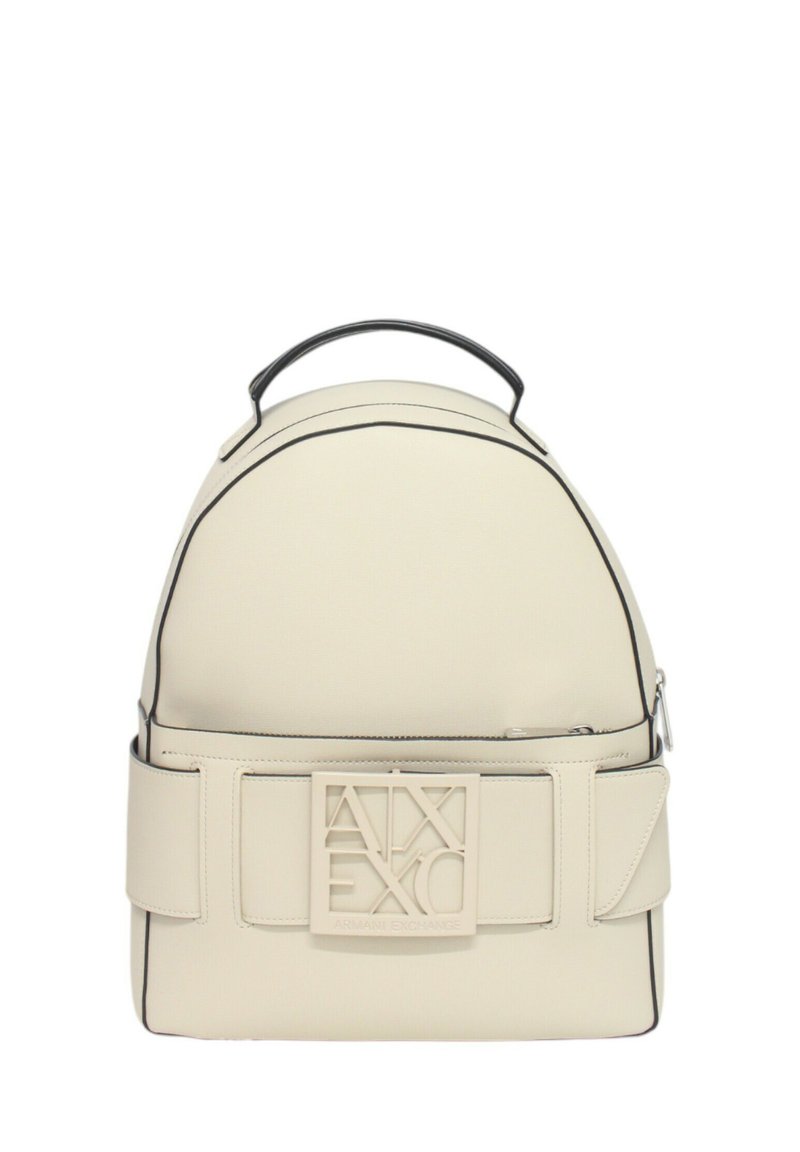 Mochila color crema con textura suave, ribete negro y un logotipo cuadrado prominente en la parte frontal. Cuenta con un asa y cierre de cremallera.