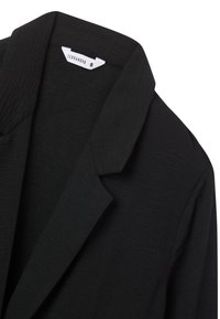 Blazer nero con una texture liscia, dotato di colletto a punta, design a un bottone singolo e etichetta visibile che indica la dimensione e il marchio.