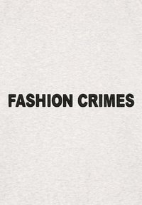 T-shirt en coton gris avec un texte noir en caractères gras qui dit "CRIMES DE MODE" en évidence sur le devant.