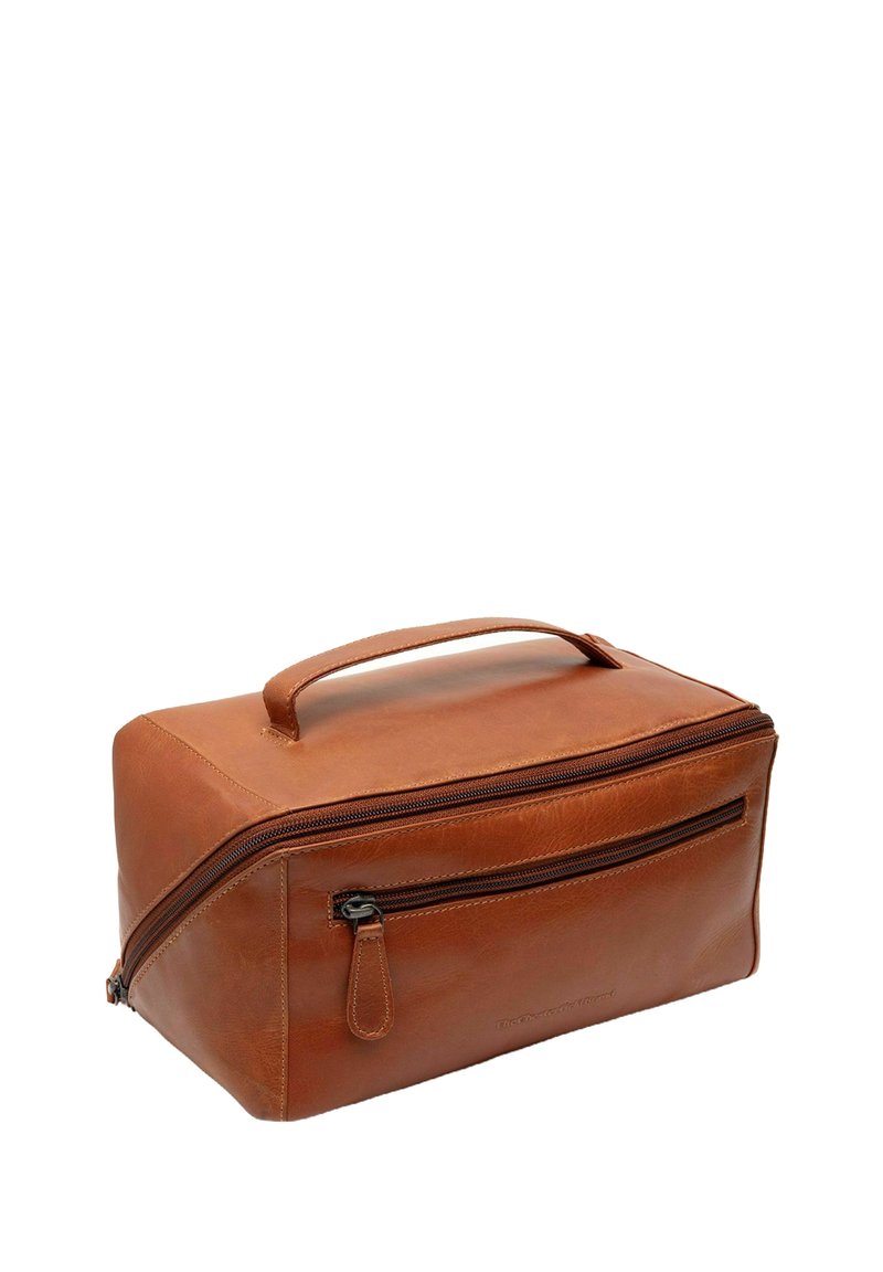 Neceser de cuero marrón con forma rectangular, un asa superior y dos cremalleras. Presenta un bolsillo delantero con cremallera y textura suave.