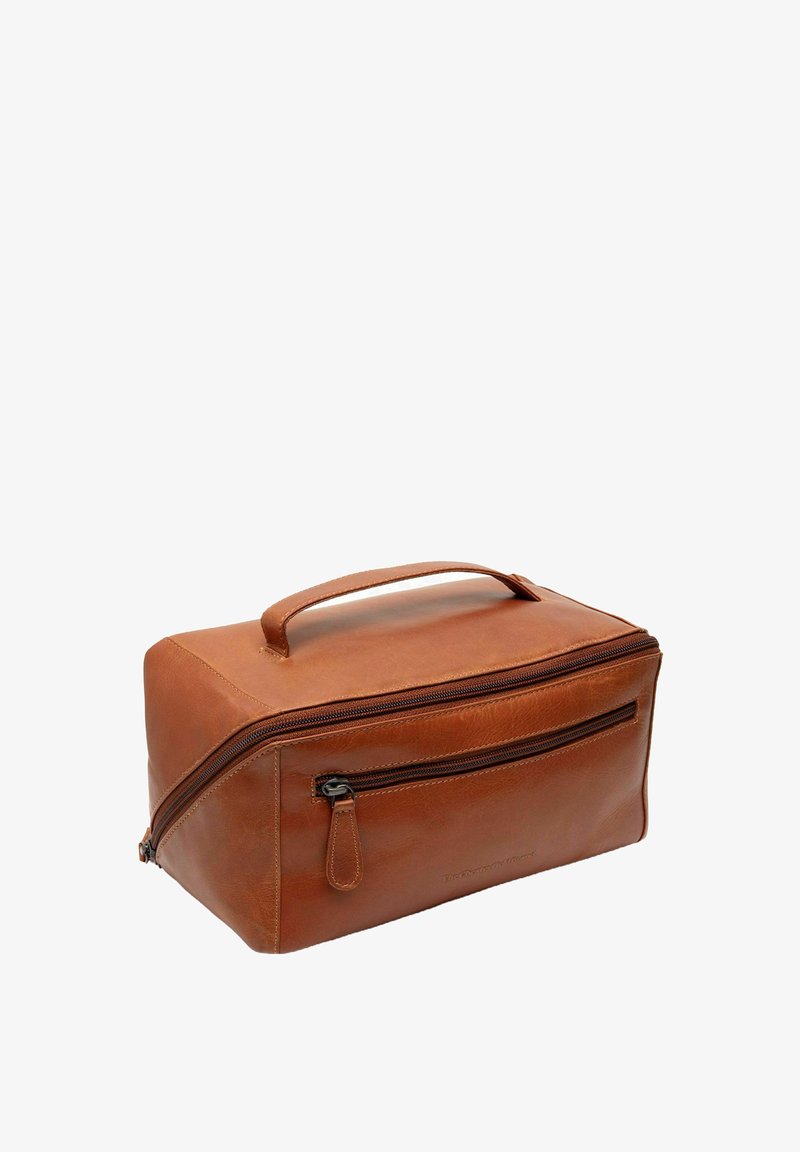 Neceser de cuero marrón con forma rectangular, un asa superior y dos cremalleras. Presenta un bolsillo delantero con cremallera y textura suave.