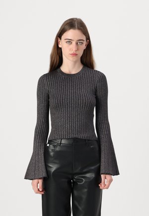 Top lungo a maniche ribbed nero con polsini svasati, realizzato in un tessuto metallico testurizzato. Indossato con pantaloni in pelle nera a vita alta.