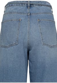 Jean en denim bleu clair à taille haute, avec deux poches arrière et des surpiqûres contrastantes le long des coutures.