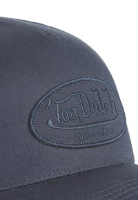 Dark blue baseball cap with a smooth fabric texture, featuring an embossed oval logo reading "Von Dutch" and "California" in matching thread.