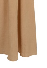 Abito in lino beige con un design fluido. Il tessuto ha una consistenza morbida e l'orlo è leggermente Curvo sul fondo per una vestibilità rilassata.