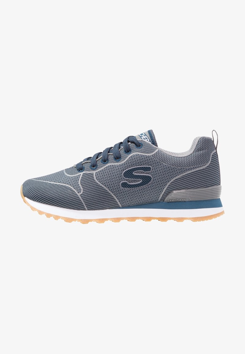 Chaussure de sport en mesh bleu avec des accents gris, bout rond, semelle en caoutchouc plate et design texturé. Présente un logo sur le côté et un système de laçage.
