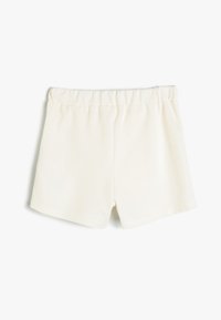 Pantalones cortos blancos cortos, hechos de una tela suave con una cinturilla elástica y una textura lisa. Sin patrones ni adornos visibles.