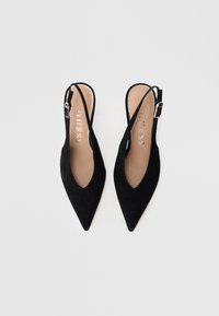 Czarne zamszowe baleriny na płaskim obcasie z zaostrzonym noskiem, rzemykami z regulowanymi sprzączkami oraz beżowymi wkładkami z logo "GUESS".