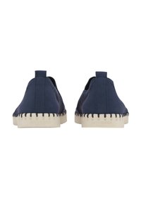 Navy slip-on shoes with a textured upper, cream rubber sole featuring visible stitching, and pull tab at the back for easy wear.