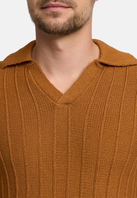 Brauner Strickpullover mit V-Ausschnitt und Kragen, mit vertikal gerippter Textur und lässiger Passform.