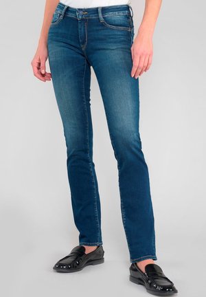 Jeans en denim de couleur bleu moyen, avec une coupe droite, fermoir à bouton et cinq poches. Détails de couture contrastés le long des coutures.