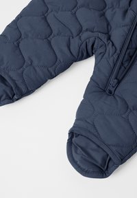 Quilted navy blue overtøj med en glat tekstur, der har lynlåslukning, manchetterede ærmer og et rundt kravedesign.
