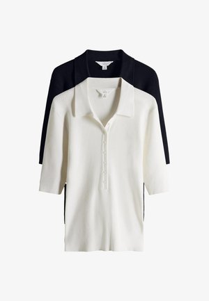 Két bordázott kötött galléros póló, egyik fehér, a másik fekete, háromnegyedes ujjakkal és gombos lezárással, fehér háttéren egymásra rakva.