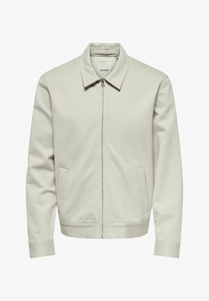 Svetlo bež zip-up jakna s ovratnikom, dolgimi rokavi in dvema stranskima žepoma, prikazana na beli podlagi.