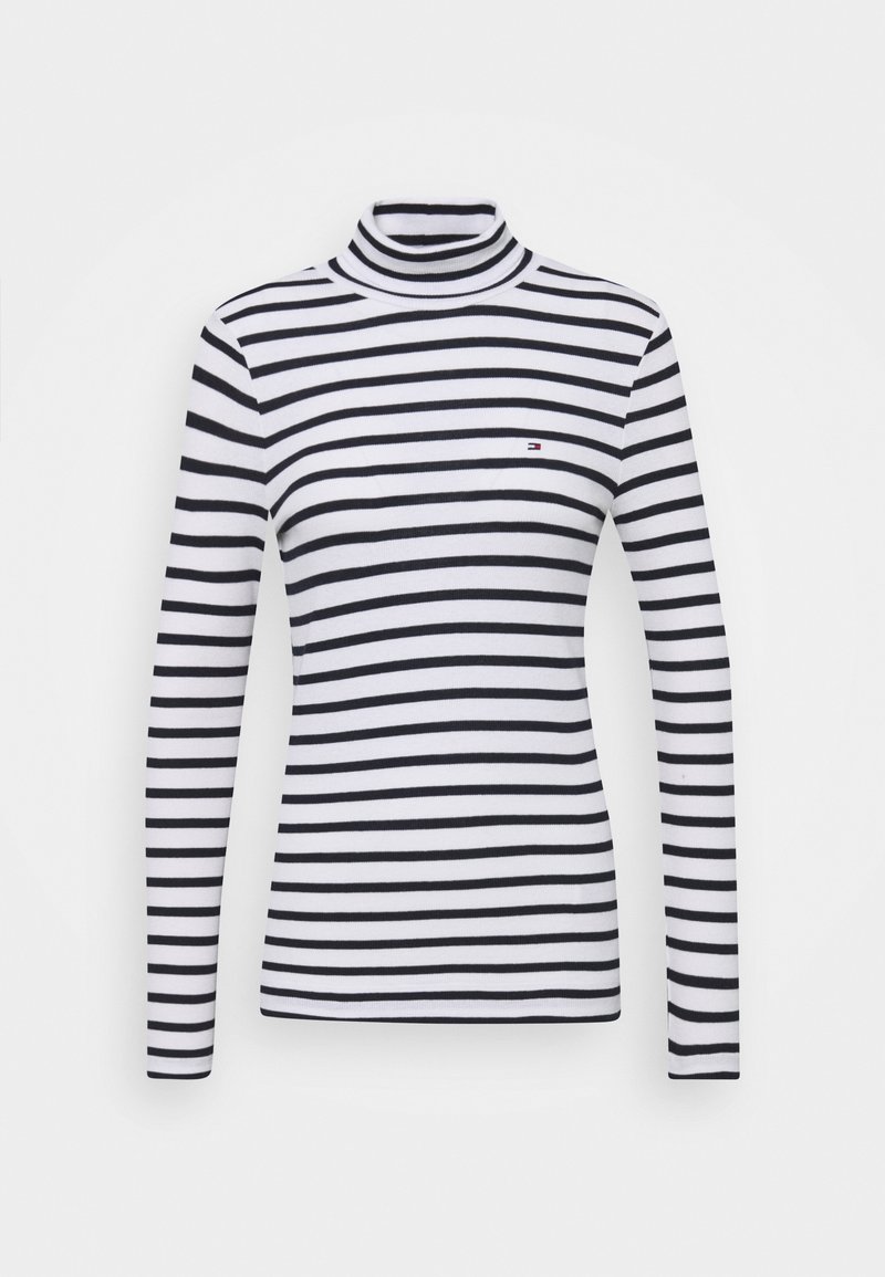 Maglione a collo alto a righe bianche e nere con maniche lunghe, realizzato in tessuto morbido. Presenta un piccolo logo sul petto. Design classico aderente.