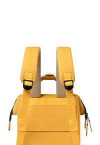 Yellow backpack features padded straps, a textured fabric finish, and dual zip pulls. The design includes a top handle for easy carrying.