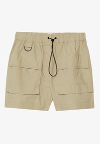 Shorts cargo beige en tissu léger, dotés d'une ceinture élastique avec cordon de serrage, deux poches avant et une boucle latérale pour accessoires.