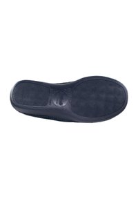 Suela de zapato de goma negra con patrón de agarre texturizado y bordes redondeados. Presenta una impresión de logo cerca del centro. Acabado suave en general.