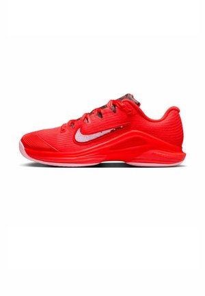 Zapatilla deportiva Nike de color rojo brillante con logo swoosh blanco, parte superior texturizada y suela amortiguada diseñada para el rendimiento deportivo.