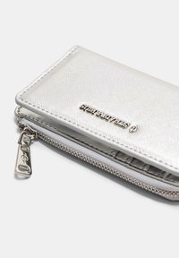 Sølv pung med tekstureret overflade, lynlås-lukning og præget logo. Kompakt design med en glat, metallisk finish.