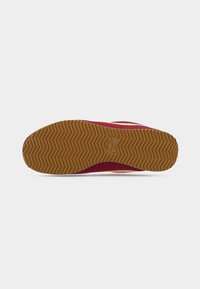 Μπορντό αθλητικό παπούτσι με υφασμένη λαστιχένια σόλα, που διαθέτει σχέδιο ψαροκόκκαλο και αποτύπωμα λογοτύπου. Διακοσμημένο με αντίθετη κίτρινη ρίγα.