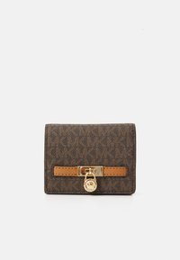 Portafoglio monogramma marrone compatto con dettaglio in oro a forma di lucchetto e accentuazione in pelle beige, su sfondo bianco.